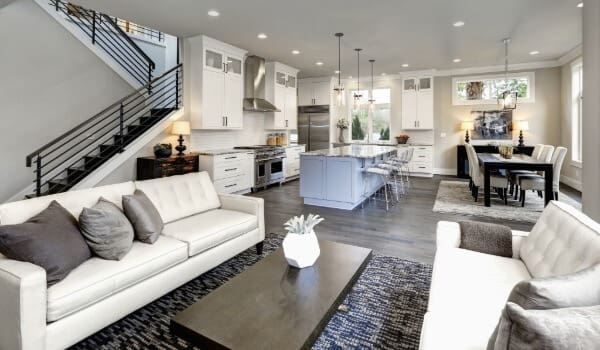 Bright, modern open-concept living space featuring a freshly painted interior with white cabinetry, neutral walls, and clean finishes throughout the kitchen and living areas.
